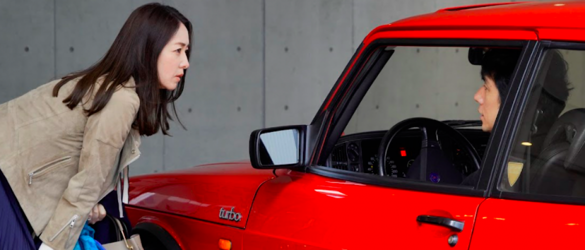 Película Dry My Car Mujer hablando con un señor que esta en un carro rojo